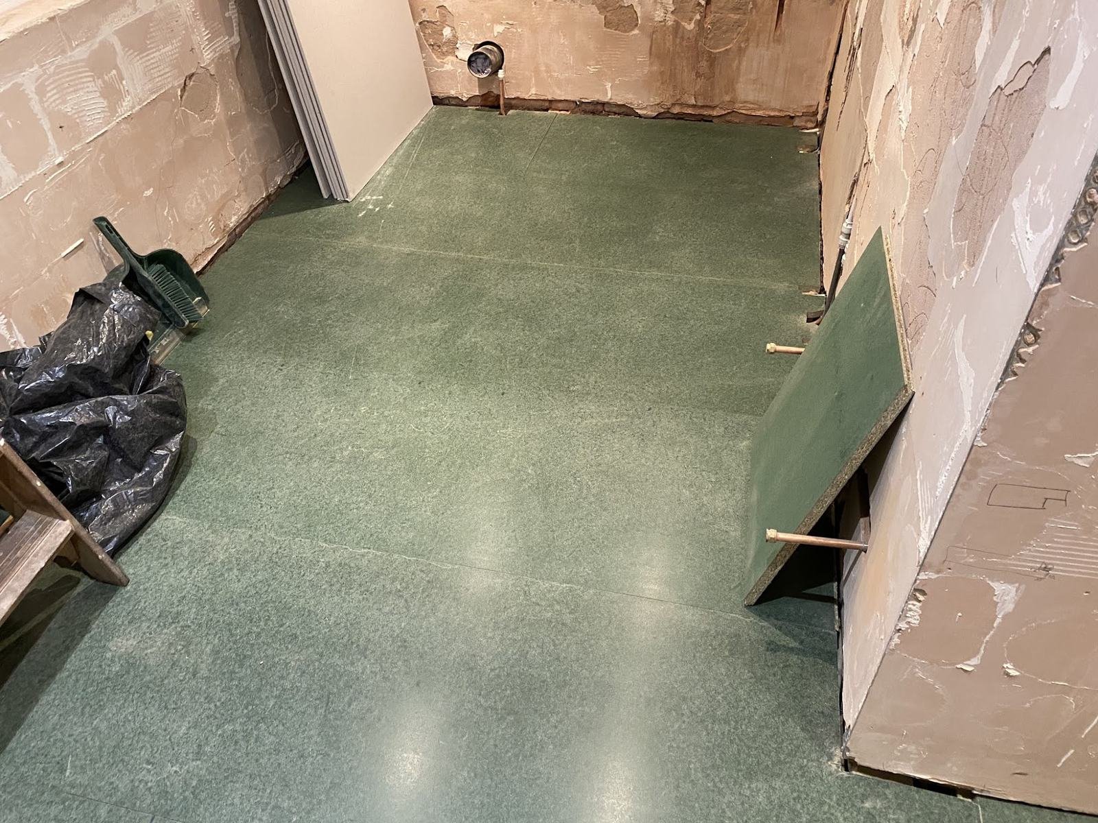 Before: bathroom stripped back to boards and bare walls