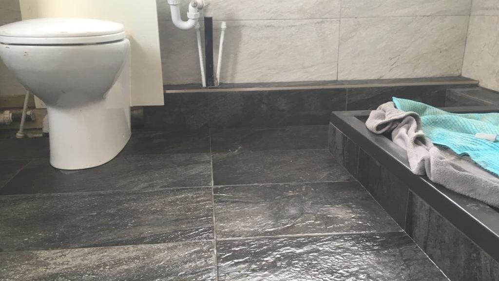 Slate-effect tiles on a bathroom floor and bath panel