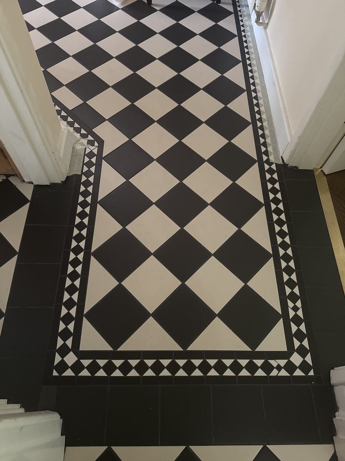 Victorian-style black and white hallway floor with a patterned border