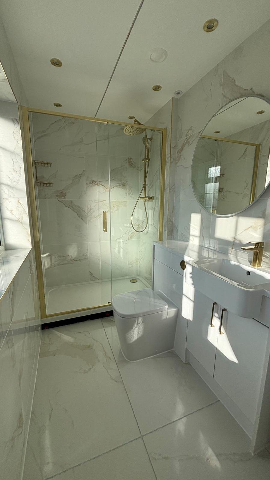 Marble-effect bathroom with brushed brass shower screen and fittings